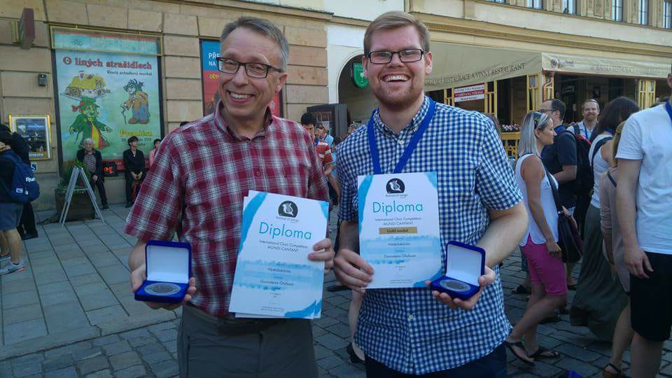 Gunnsteinn Ólafsson kórstjóri og Guðmundur Alfreðsson, formaður stjórnar Háskólakórsins, kampakátir með gullið. ""
