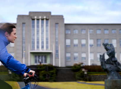 Stelpa á hjóli við Aðalbyggingu