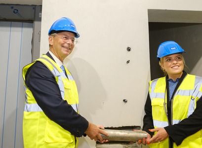 Rektor og ráðherra leggja nýjan hornstein að Sögu á fyrstu hæð hússins. 