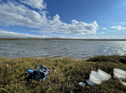 Rannsókn Viktors í náttúrunni. Bjartur himinn, vatn og verkfæri úrí móa.