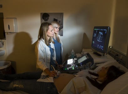 Ljósmæður að taka sónarmynd af barnshafandi konu