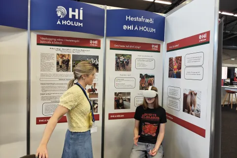 Bás HÍ á Hólum á Vísindavöku krakki að prufa sýndarverugleraugu með starfsmanni